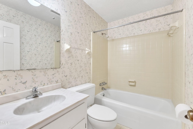 full bathroom featuring tiled shower / bath, vanity, a textured ceiling, and toilet