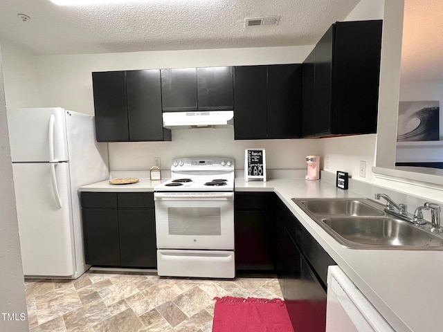 kitchen with a textured ceiling, sink, and white appliances