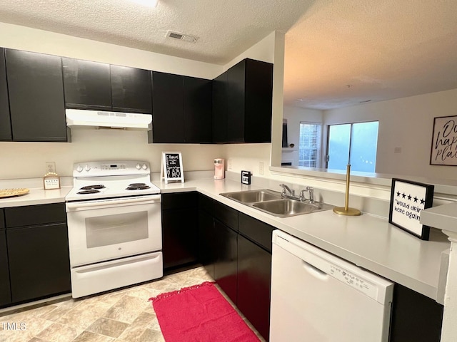 kitchen featuring a textured ceiling, sink, and white appliances