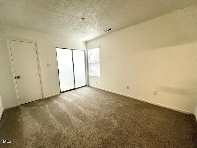 unfurnished bedroom featuring dark carpet and a textured ceiling