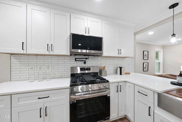 kitchen featuring white cabinets, decorative light fixtures, stainless steel appliances, and ornamental molding