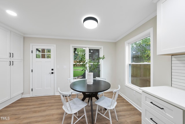 dining room featuring crown molding and light hardwood / wood-style flooring