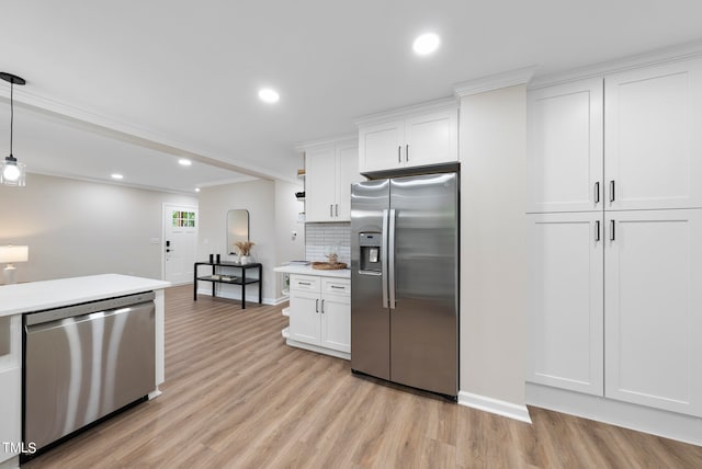 kitchen with pendant lighting, light wood-type flooring, tasteful backsplash, white cabinetry, and stainless steel appliances