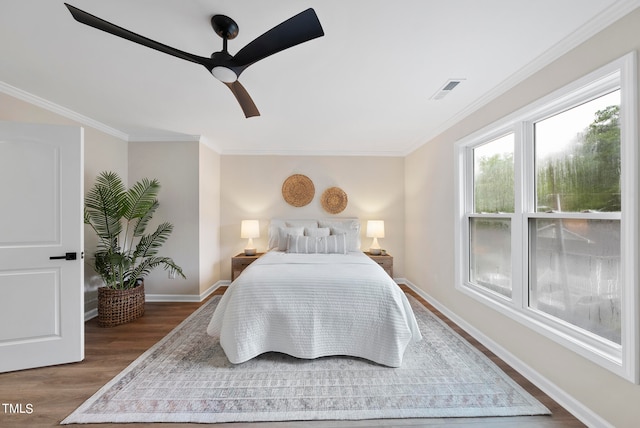 bedroom with dark hardwood / wood-style flooring, ceiling fan, and ornamental molding