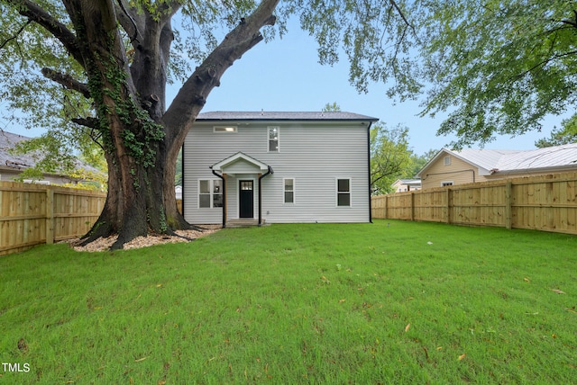 back of property featuring a lawn