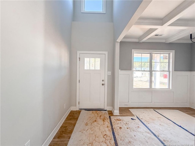 doorway to outside featuring coffered ceiling, beam ceiling, and crown molding