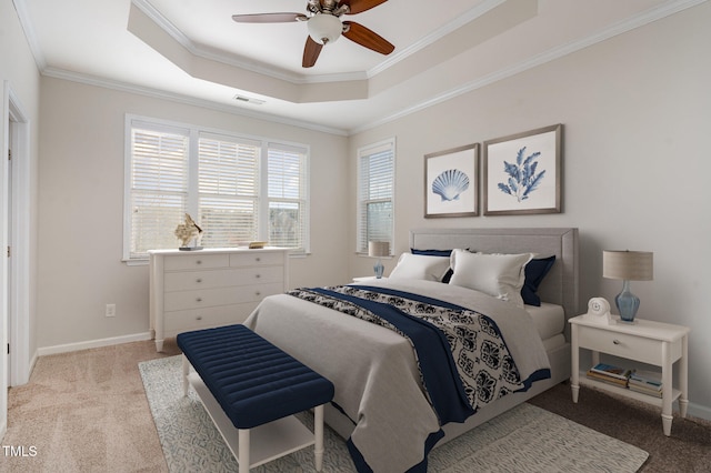 carpeted bedroom featuring ceiling fan, a raised ceiling, and ornamental molding