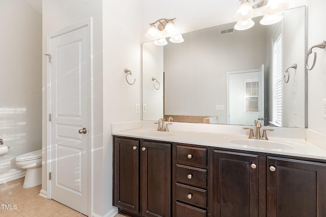 bathroom with tile patterned flooring, vanity, and toilet