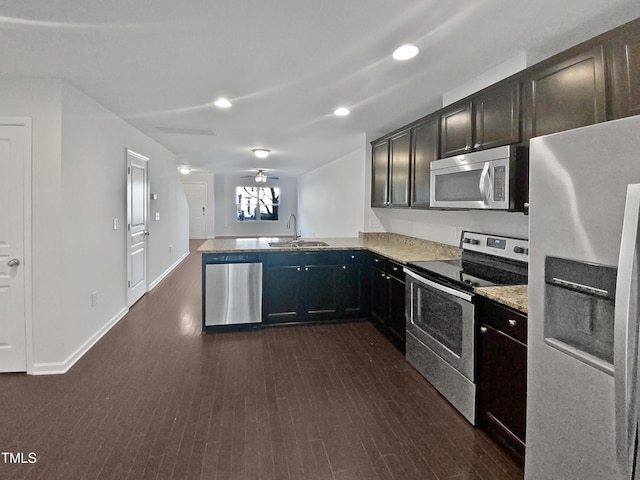 kitchen with dark wood-type flooring, sink, ceiling fan, appliances with stainless steel finishes, and kitchen peninsula