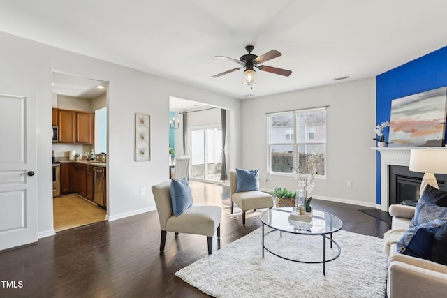 living room featuring dark wood-type flooring and ceiling fan