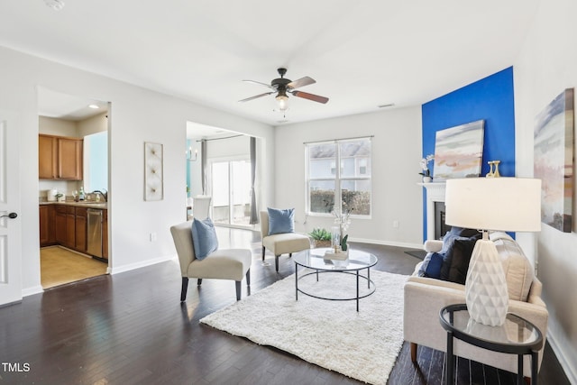 living room with dark wood-type flooring and ceiling fan