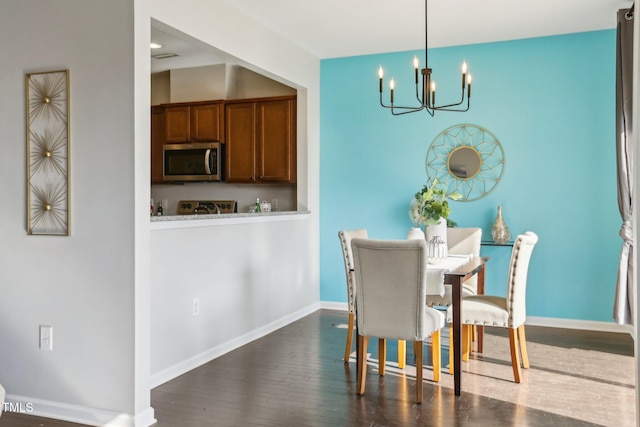 dining space with dark hardwood / wood-style flooring and a chandelier