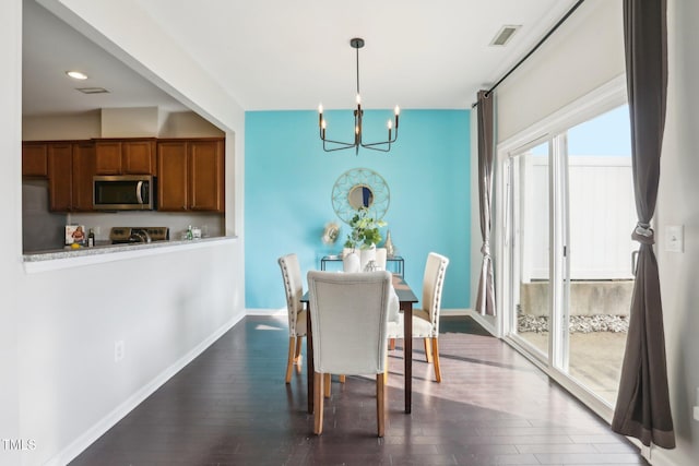 dining area with an inviting chandelier and dark wood-type flooring