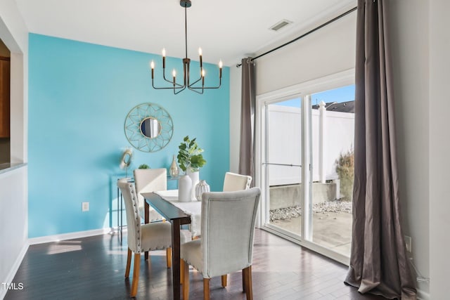 dining area with hardwood / wood-style flooring and a notable chandelier