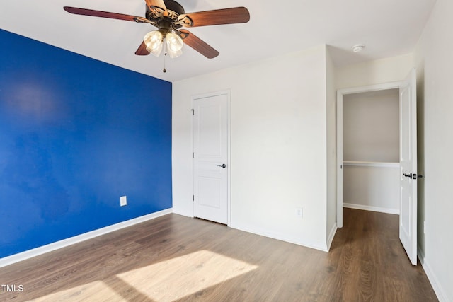 unfurnished bedroom featuring hardwood / wood-style floors, a closet, and ceiling fan