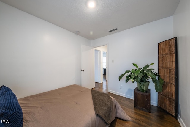 bedroom with dark wood-type flooring and a textured ceiling