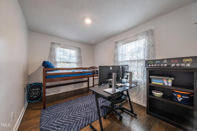 office with a textured ceiling, a healthy amount of sunlight, and dark hardwood / wood-style floors