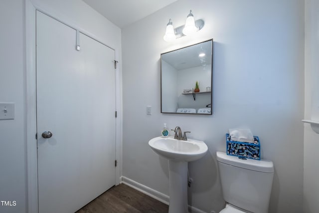 bathroom with toilet and wood-type flooring