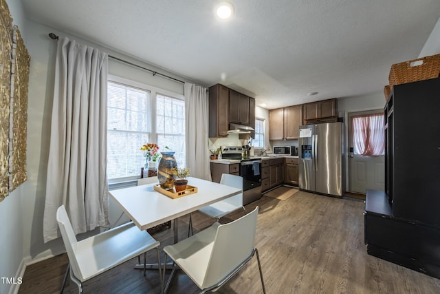 kitchen with hardwood / wood-style flooring, dark brown cabinetry, a textured ceiling, and appliances with stainless steel finishes