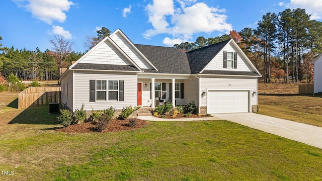 view of front facade with a front yard, central air condition unit, a garage, and covered porch