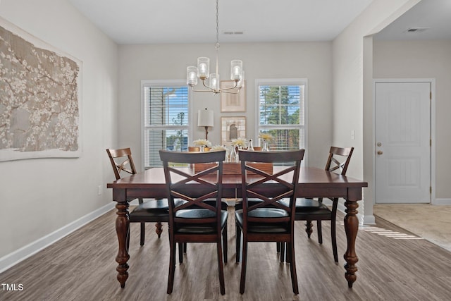 dining room featuring hardwood / wood-style floors and an inviting chandelier