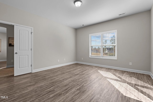 spare room with dark hardwood / wood-style flooring