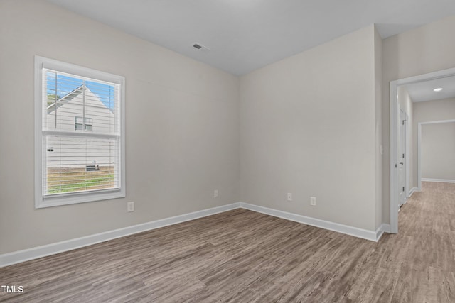 empty room featuring a wealth of natural light and hardwood / wood-style floors