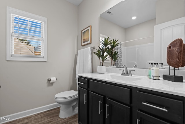 bathroom featuring a shower, wood-type flooring, vanity, and toilet