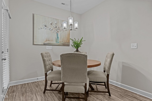 dining area featuring a notable chandelier and wood-type flooring