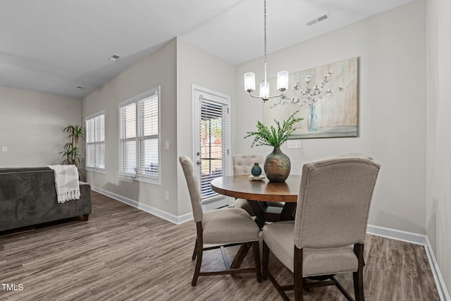 dining room with wood-type flooring and a notable chandelier