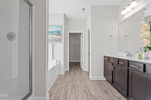 bathroom with hardwood / wood-style flooring, vanity, and independent shower and bath