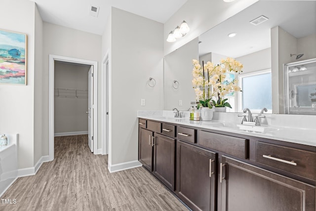 bathroom featuring hardwood / wood-style floors, vanity, and a bathing tub