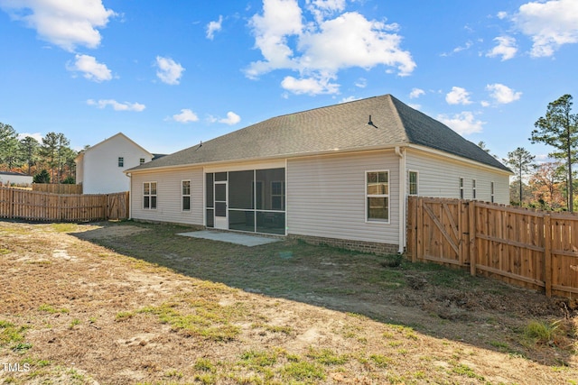 back of house featuring a sunroom and a lawn