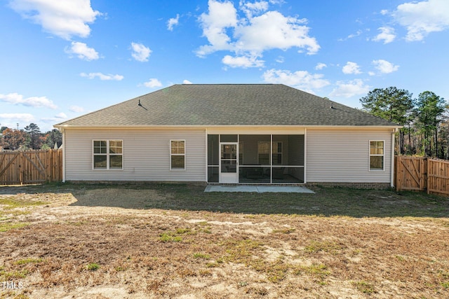 back of property featuring a sunroom, a patio area, and a yard