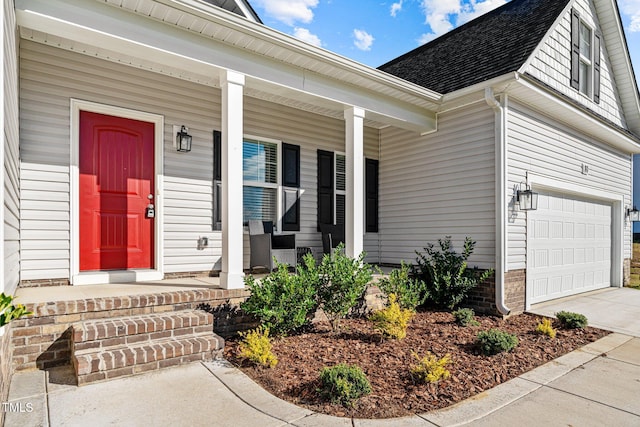 entrance to property featuring a porch and a garage