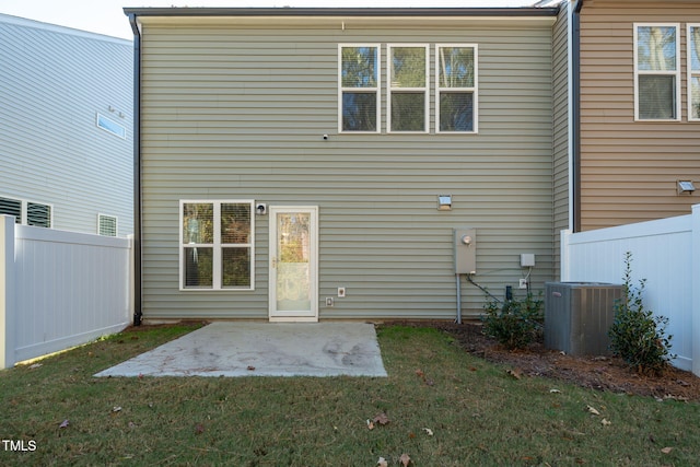 back of property featuring central AC unit, a patio, and a lawn