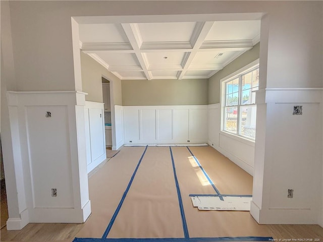 interior space with beamed ceiling, coffered ceiling, and crown molding