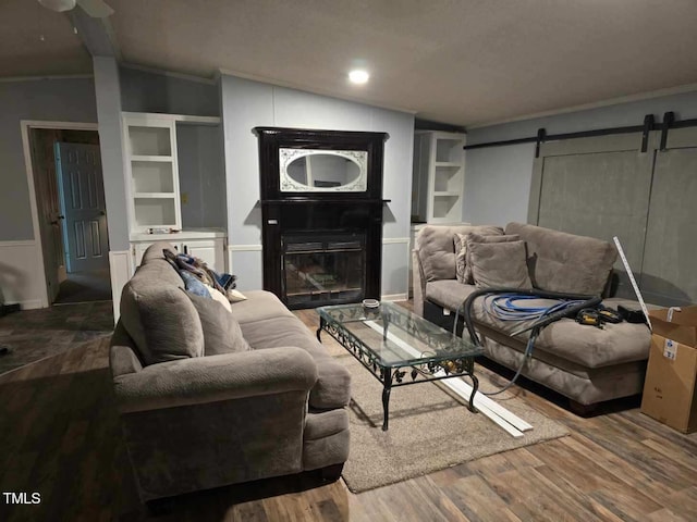 living room with a barn door, ceiling fan, hardwood / wood-style floors, and built in features