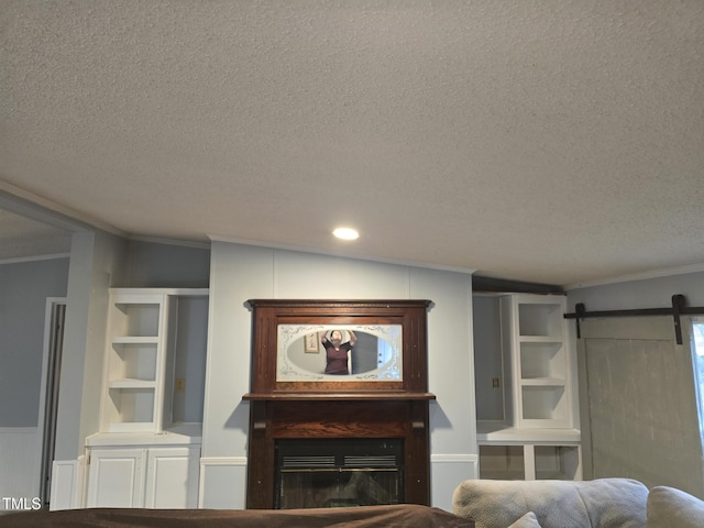 living room featuring vaulted ceiling, a barn door, a textured ceiling, and ornamental molding