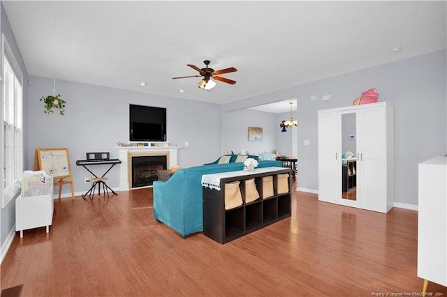 living room featuring wood-type flooring and ceiling fan with notable chandelier