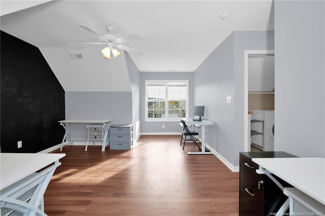 home office featuring ceiling fan, dark hardwood / wood-style flooring, washing machine and clothes dryer, and vaulted ceiling