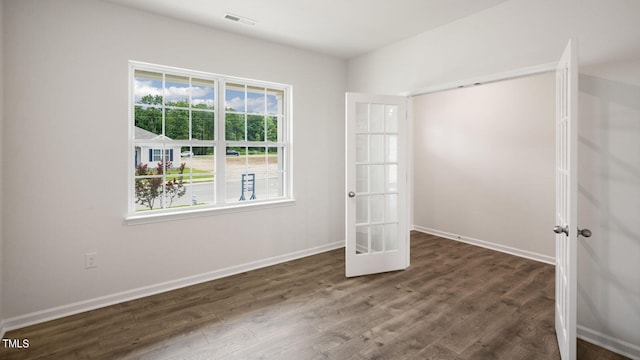 unfurnished room with dark hardwood / wood-style flooring and french doors