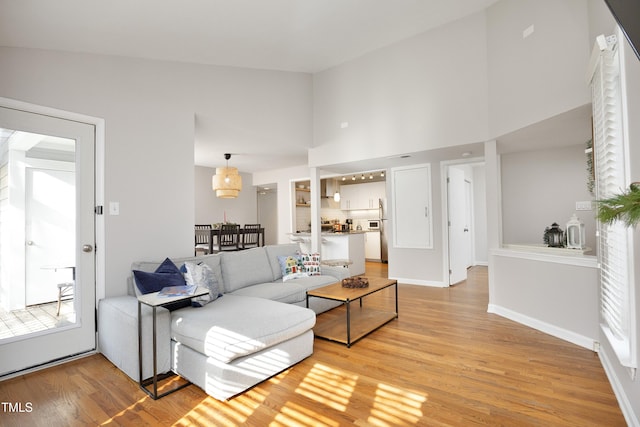 living room with hardwood / wood-style floors and high vaulted ceiling