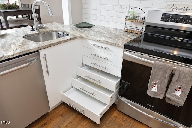 kitchen with white cabinets, appliances with stainless steel finishes, dark wood-type flooring, and sink