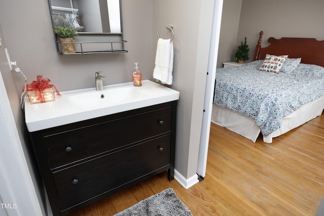 bedroom featuring light hardwood / wood-style flooring and sink