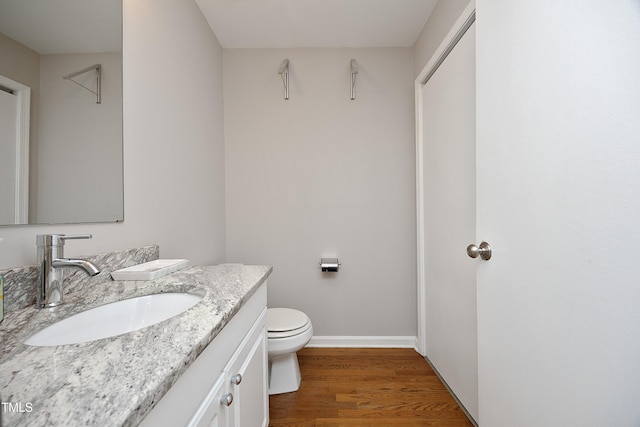 bathroom featuring wood-type flooring, vanity, and toilet