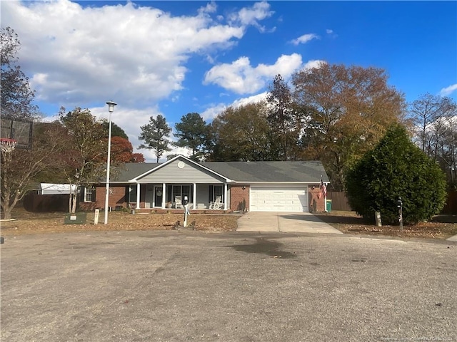 ranch-style house with a porch and a garage