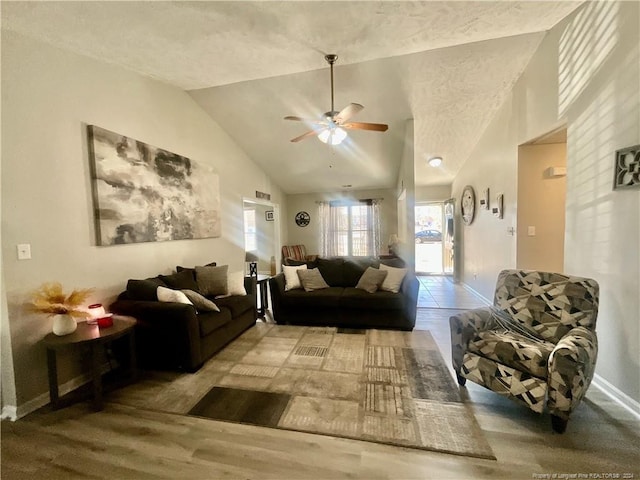 living room with a textured ceiling, ceiling fan, hardwood / wood-style floors, and lofted ceiling