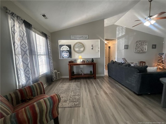 living room featuring ceiling fan, vaulted ceiling, and hardwood / wood-style flooring