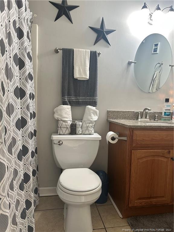 bathroom with tile patterned flooring, vanity, a shower with shower curtain, and toilet